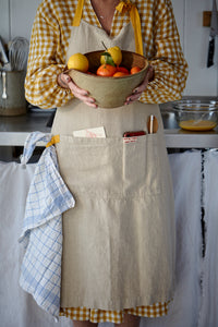 Natural linen apron with pocket and yellow straps. 